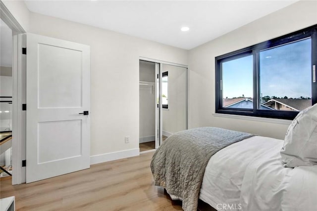 bedroom featuring recessed lighting, a closet, light wood-type flooring, and baseboards