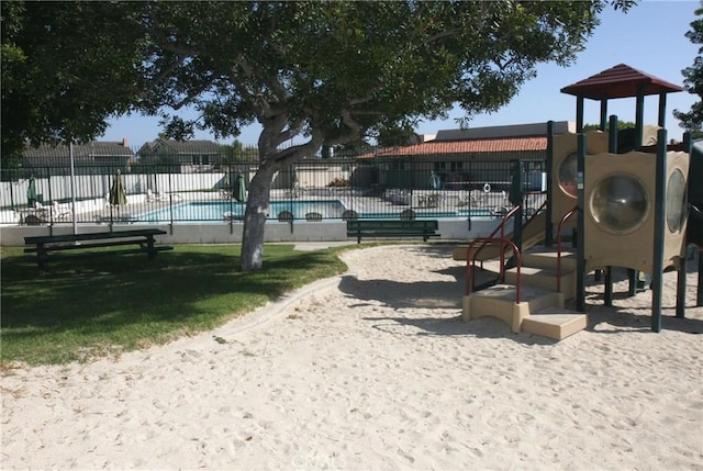 communal playground with fence and a community pool