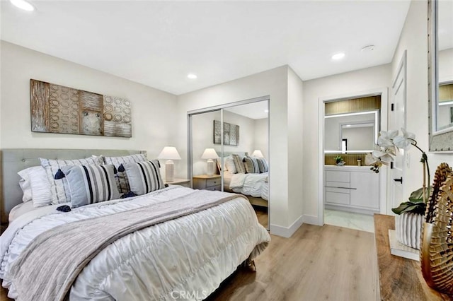 bedroom featuring a closet, baseboards, wood finished floors, and recessed lighting