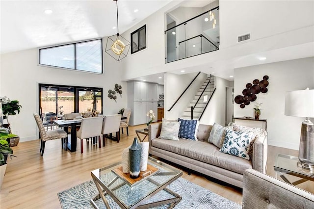 living room featuring a towering ceiling and light hardwood / wood-style flooring