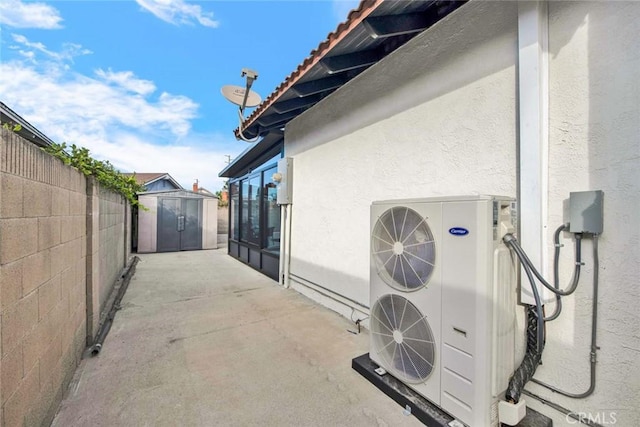 view of property exterior featuring ac unit, fence, a storage unit, and stucco siding