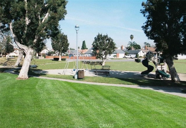 view of property's community featuring playground community and a lawn