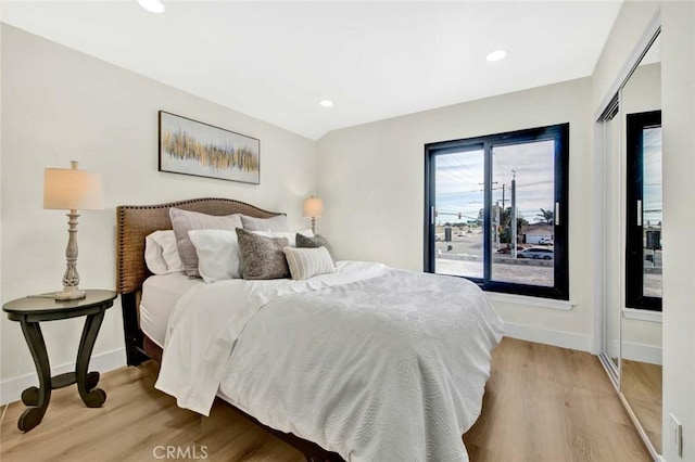 bedroom with baseboards, wood finished floors, and recessed lighting