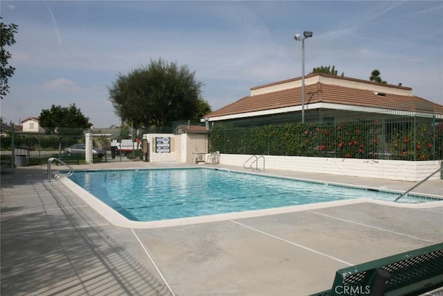 community pool featuring fence and a patio