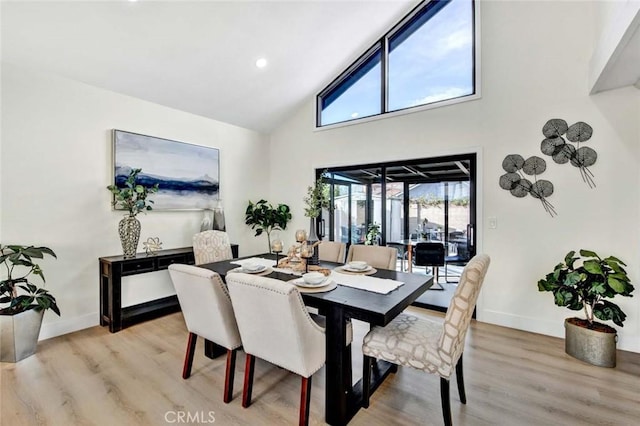 dining area featuring high vaulted ceiling, recessed lighting, light wood-type flooring, and baseboards