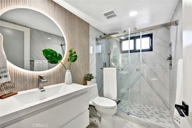 bathroom with marble finish floor, a marble finish shower, visible vents, toilet, and vanity