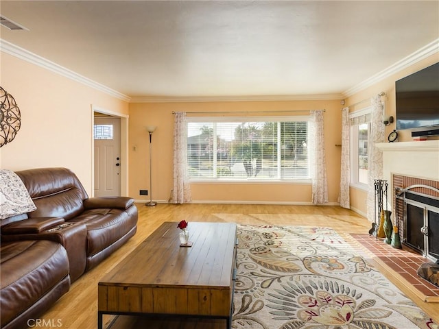 living room featuring crown molding, a fireplace, and light hardwood / wood-style flooring