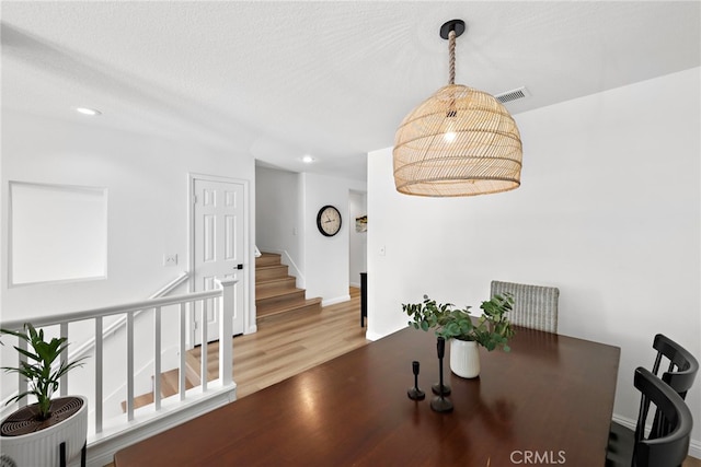 dining area featuring visible vents, stairway, wood finished floors, a textured ceiling, and recessed lighting