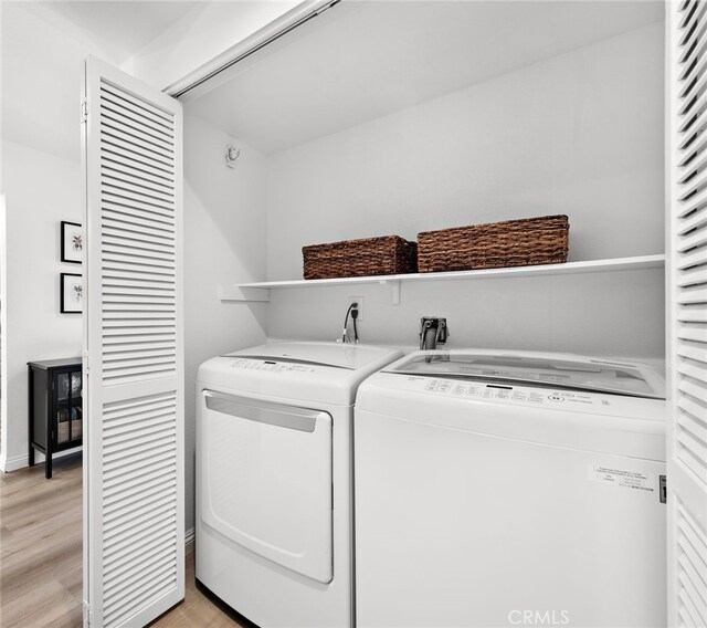 laundry room featuring light wood-type flooring and independent washer and dryer