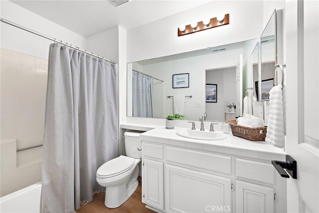 full bathroom featuring visible vents, toilet, wood finished floors, shower / tub combo with curtain, and vanity