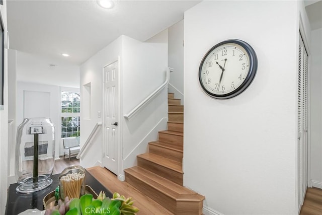 stairs with wood finished floors and recessed lighting