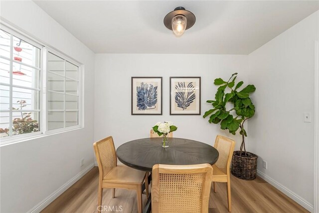 dining space featuring light wood finished floors and baseboards