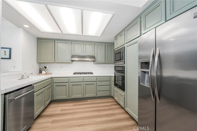 33144 Ocean Rdg, Dana Point, CA 92629 - kitchen with appliances with stainless steel finishes, green cabinets, tile countertops, under cabinet range hood, and light wood-style floors