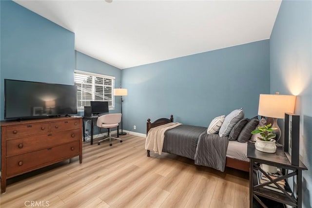 bedroom featuring light wood-type flooring, lofted ceiling, and baseboards