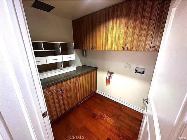 clothes washing area featuring dark hardwood / wood-style flooring, hookup for a washing machine, and cabinets