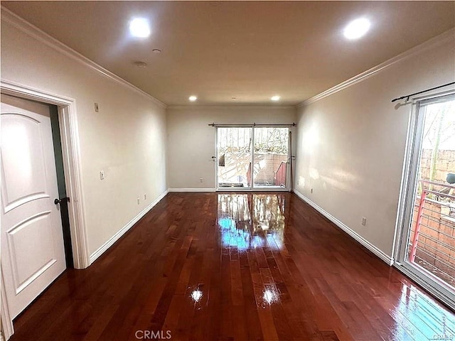 empty room featuring dark wood-type flooring, a healthy amount of sunlight, and crown molding