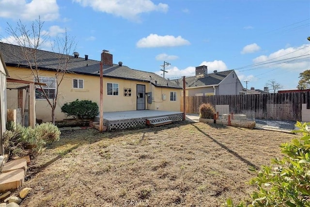 back of house featuring a wooden deck and a yard