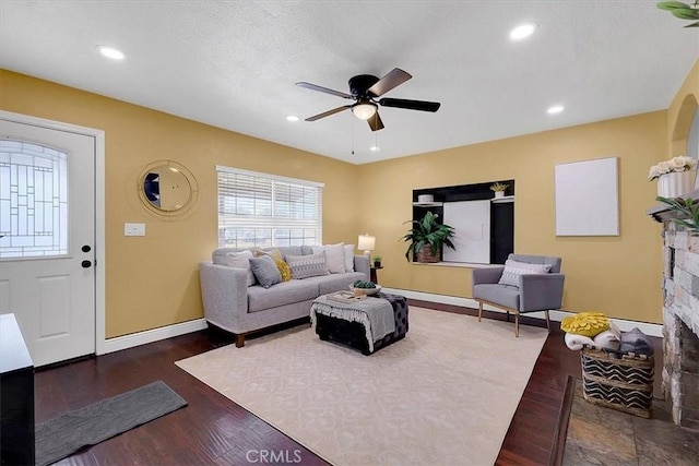 living room with ceiling fan and dark hardwood / wood-style flooring