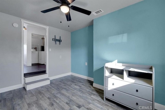 unfurnished bedroom featuring washing machine and clothes dryer, ceiling fan, and light hardwood / wood-style flooring