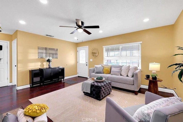 living room with ceiling fan and dark hardwood / wood-style flooring