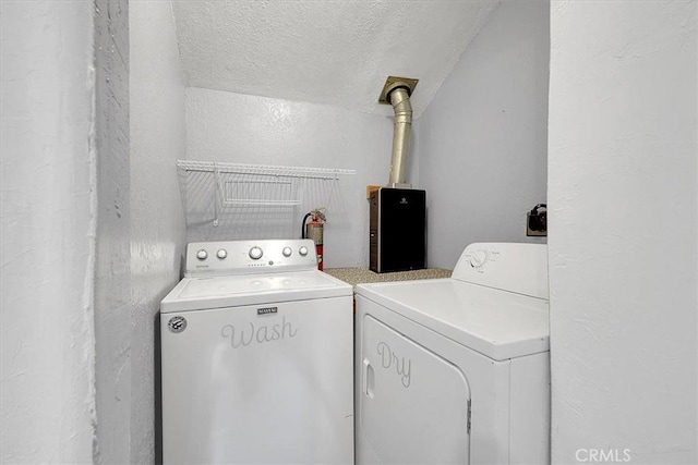 laundry room with separate washer and dryer and a textured ceiling