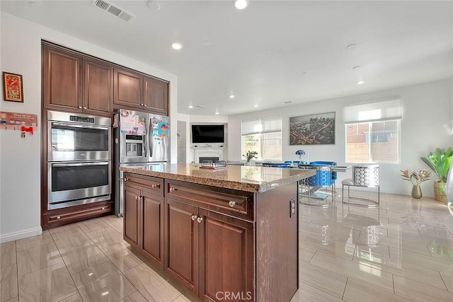 kitchen featuring light stone countertops, appliances with stainless steel finishes, and a kitchen island