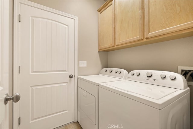 clothes washing area with cabinets and washer and dryer