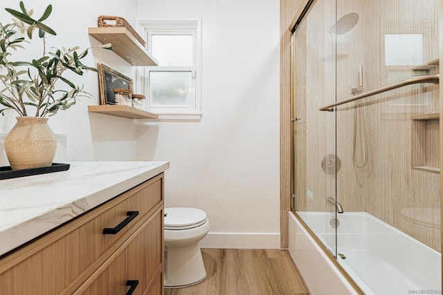 full bathroom with wood-type flooring, toilet, combined bath / shower with glass door, and vanity