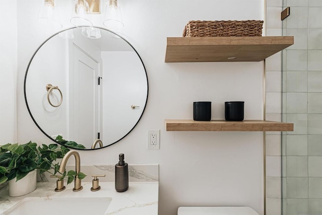 bathroom with tiled shower, vanity, and toilet