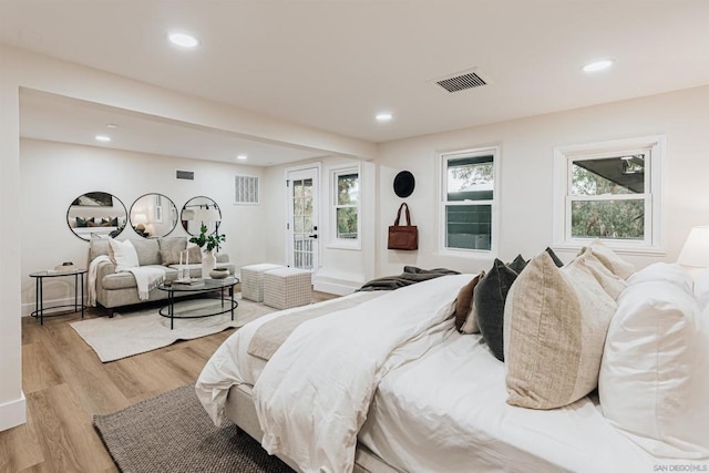 bedroom with multiple windows and light wood-type flooring