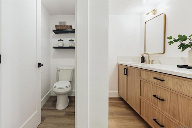 bathroom featuring vanity, hardwood / wood-style floors, and toilet