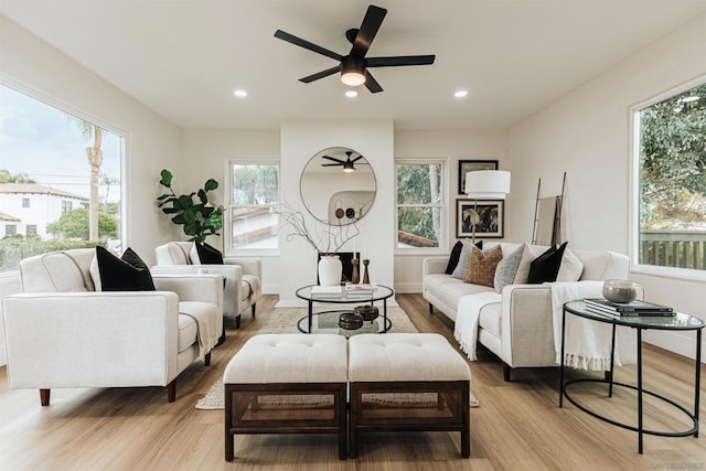 living room with a wealth of natural light, ceiling fan, and light wood-type flooring