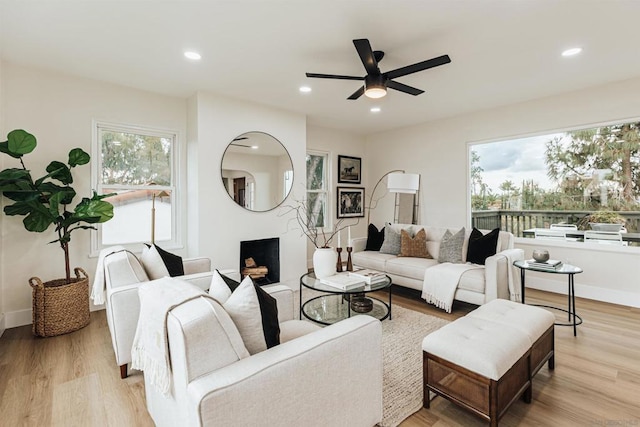 living room with plenty of natural light, ceiling fan, and light hardwood / wood-style flooring