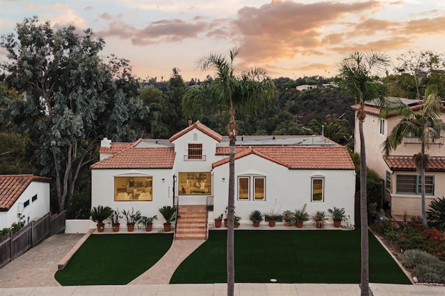 mediterranean / spanish house featuring a yard