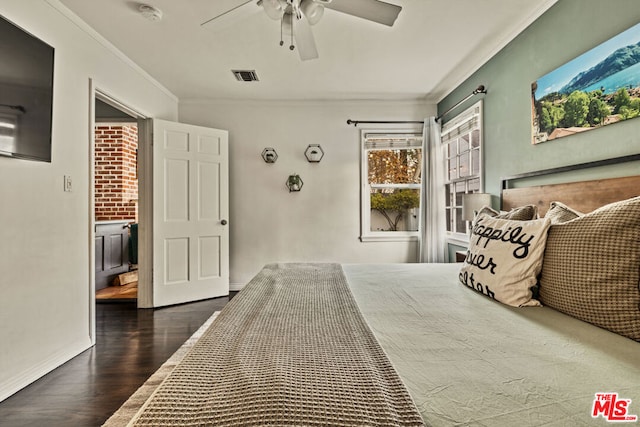 bedroom with ornamental molding, dark hardwood / wood-style floors, and ceiling fan