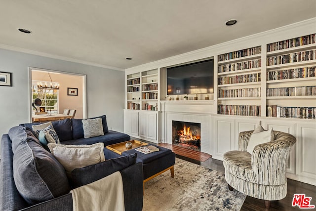 living room with dark hardwood / wood-style flooring, a notable chandelier, and ornamental molding