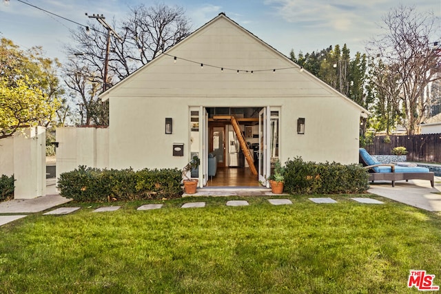 view of front facade with an outdoor structure and a front yard