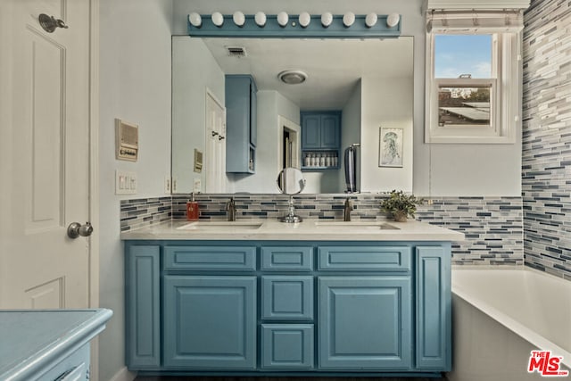 bathroom featuring vanity, a tub to relax in, and backsplash