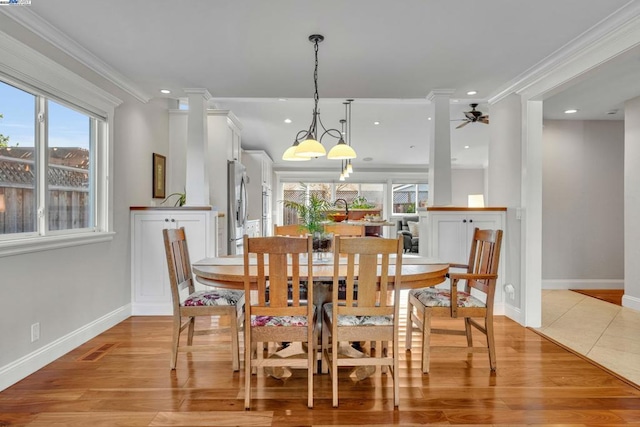 dining space featuring a healthy amount of sunlight, ornamental molding, and light hardwood / wood-style flooring