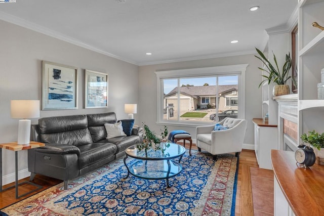 living room with a tile fireplace and ornamental molding