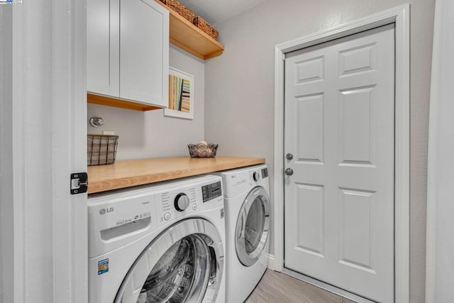 laundry room featuring cabinets, independent washer and dryer, and light hardwood / wood-style floors