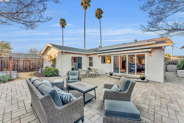 rear view of house featuring an outdoor living space, a patio, and solar panels