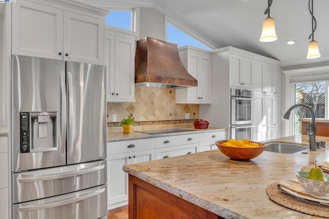 kitchen with pendant lighting, sink, white cabinetry, stainless steel appliances, and custom exhaust hood