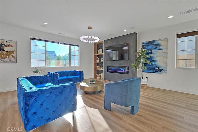 living room featuring a large fireplace and light hardwood / wood-style floors