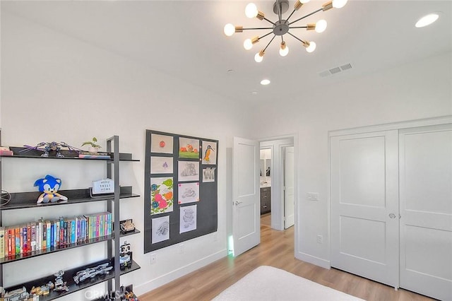 bedroom with an inviting chandelier and light hardwood / wood-style floors