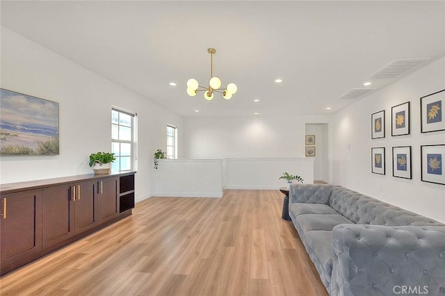 living room with light hardwood / wood-style flooring and a chandelier