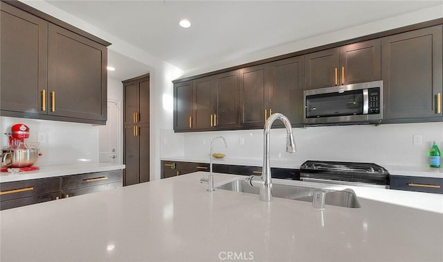 kitchen with sink, range, and dark brown cabinetry