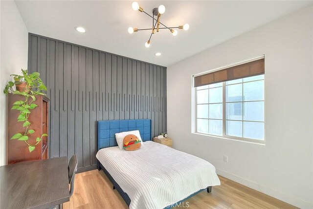 bedroom with a notable chandelier and light hardwood / wood-style flooring