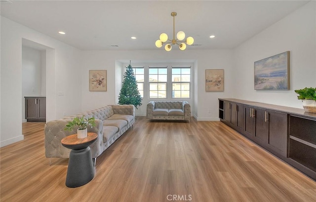 living room with an inviting chandelier and light hardwood / wood-style floors