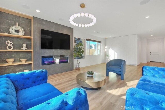 living room featuring a large fireplace and wood-type flooring